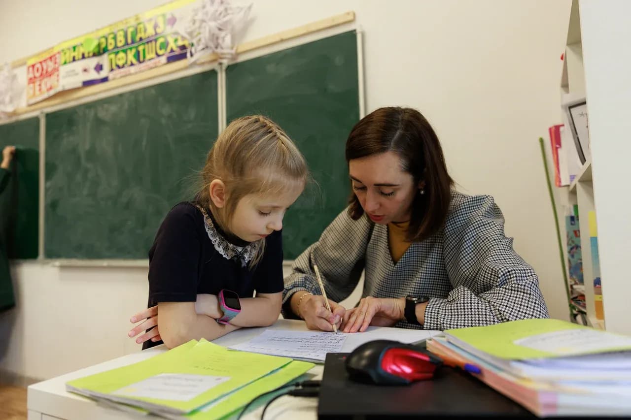 Педагог помогает ученице с письменным заданием